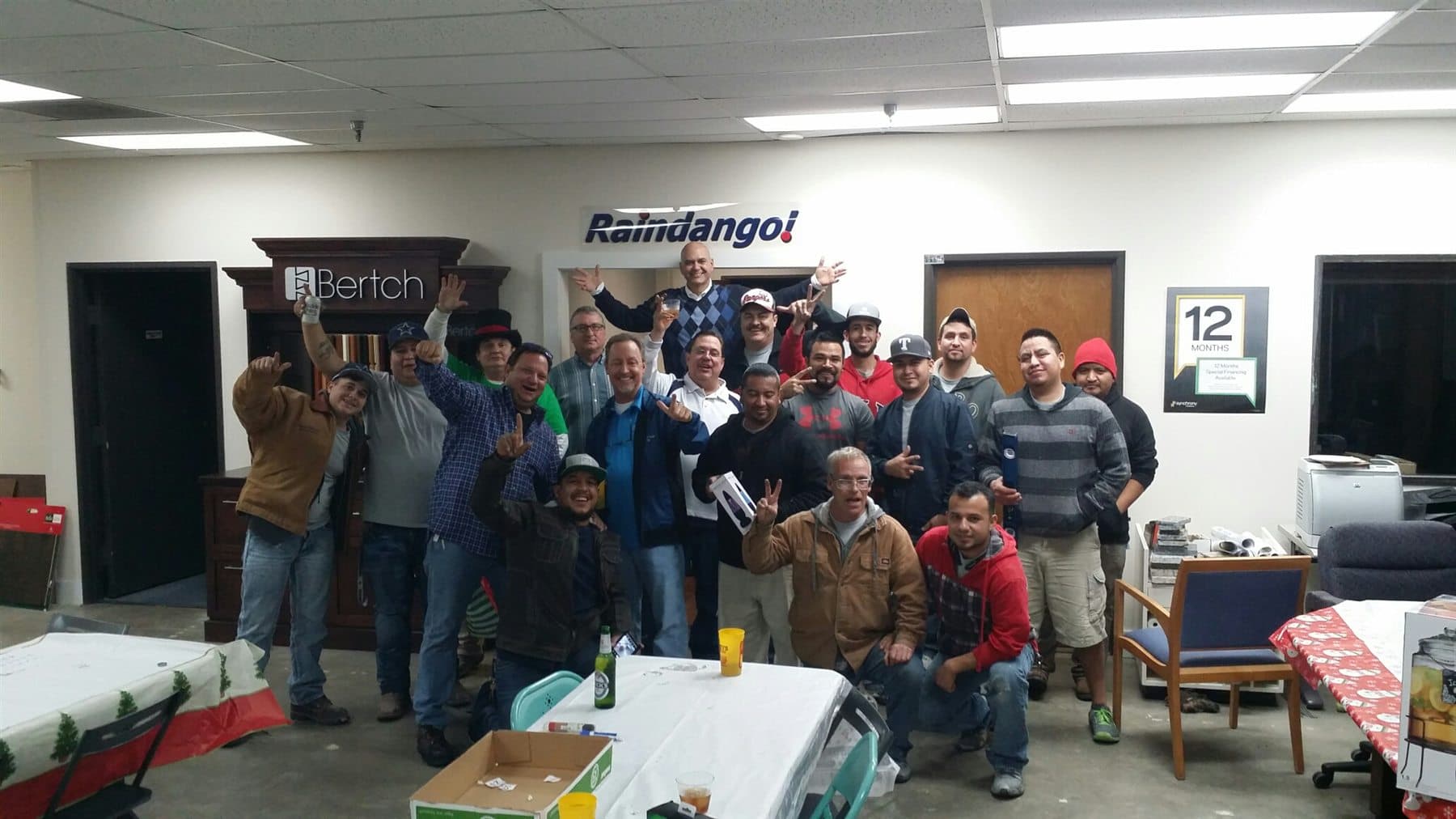 The Raindango Remodeling team gathered beneath the company sign